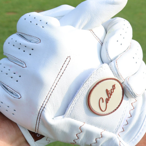 White cabretta leather Calico Golf Glove with a Calico ball marker on the strap